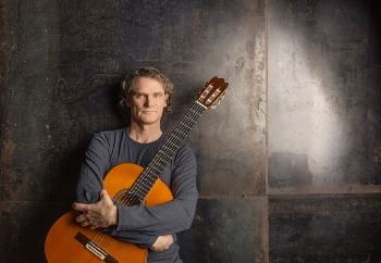 Man holding guitar named Jesse Cook